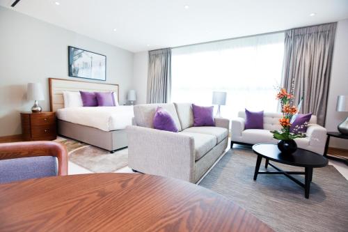 a living room with a couch and a bed at Sanctum Belsize Road in London