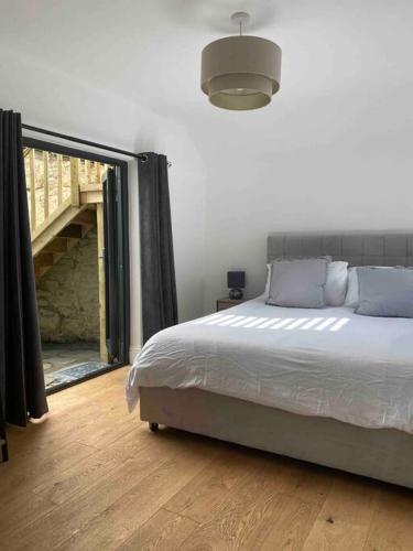 a bedroom with a bed and a large window at Charming Apartment BARBICAN/HOE PARKING,Courtyard! in Plymouth