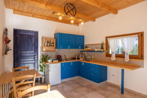 cocina con armarios azules, mesa y sillas en La Casa Del Sole en Gradara