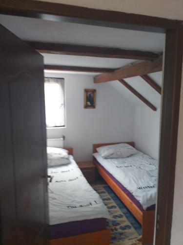 - 2 lits dans une petite chambre avec fenêtre dans l'établissement Cabana Bradul, à Colibiţa