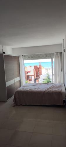 - une chambre avec un grand lit et une grande fenêtre dans l'établissement Departamento, à Puerto Madryn