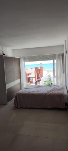 a bedroom with a large bed and a large window at Departamento in Puerto Madryn