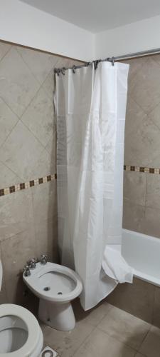 a bathroom with a toilet and a shower curtain at Departamento in Puerto Madryn