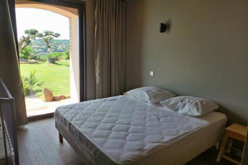 un lit dans une chambre avec une grande fenêtre dans l'établissement Pierre Jean 1823 villa, à Sainte-Maxime