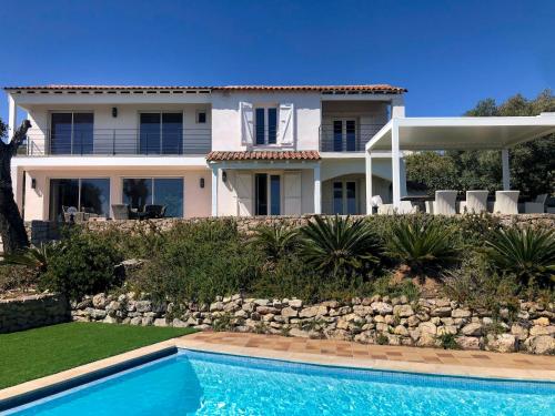 une maison avec une piscine devant une maison dans l'établissement Bleu Comme Toit 3425, aux Issambres