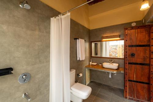 a bathroom with a toilet and a sink at 1br Cottage with Pool - Lake Escape by Roamhome in Udaipur