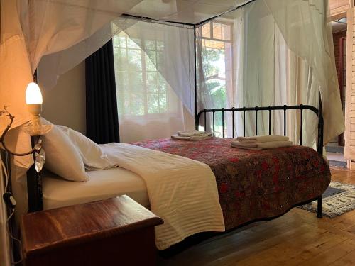 1 dormitorio con cama y ventana en La Locanda, en Ruhengeri