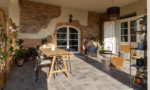 um pátio com uma mesa de madeira e cadeiras em The Olive Grove in Tuscany em Toiano