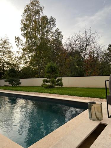 a swimming pool with a bench next to a fence at Les Trois Cyprès in Blois