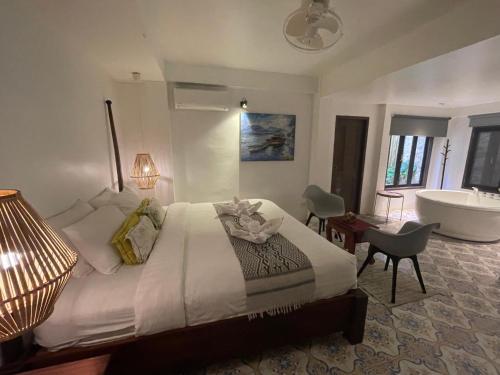 a bedroom with a bed and a bathroom with a tub at Moonlight Champa Riverview in Luang Prabang