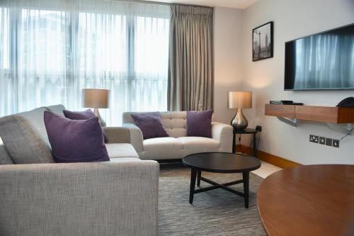 a living room with a couch and a table at Sanctum Belsize Road in London