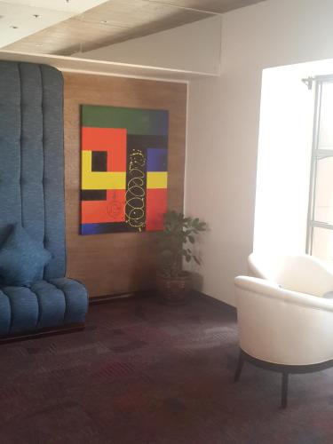 a living room with a couch and a painting on the wall at Boma Inn Eldoret in Eldoret