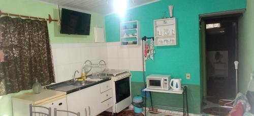una pequeña cocina con fregadero y microondas en El Remanso, en Durazno