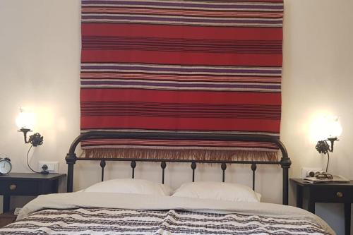 a blanket hanging above a bed with two night stands at Erofili cottage house in Elounda