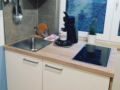 eine Küchentheke mit einer Spüle und einer Kaffeemaschine in der Unterkunft Fewo Zum Sonnenschein in Simmerath