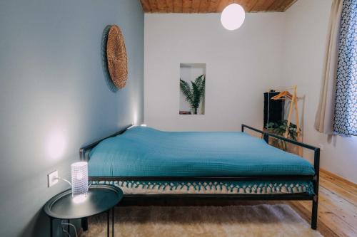 Un dormitorio con una cama azul y una mesa en JorJ'Inn en Lentekhi