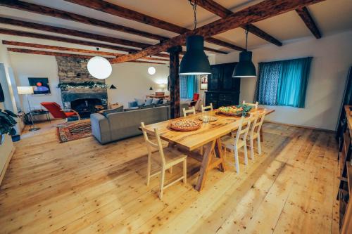 una gran sala de estar con mesa de madera y sillas. en JorJ'Inn en Lentekhi