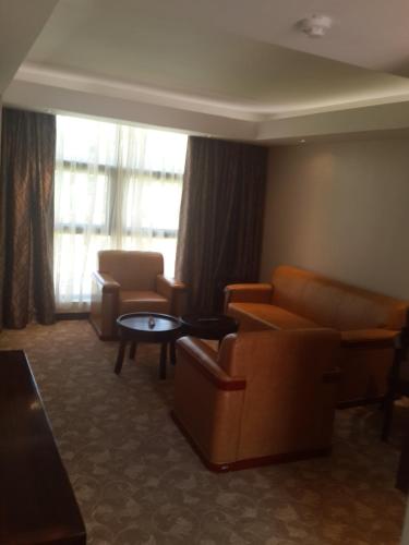 a hotel room with couches and chairs and a table at Boma Inn Eldoret in Eldoret
