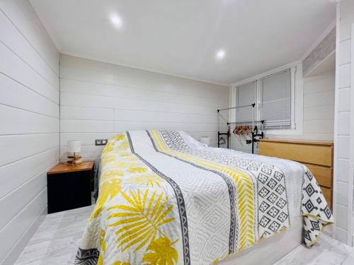 a bedroom with a bed with a yellow and white blanket at P.EMPORDA 30 BJ in Empuriabrava