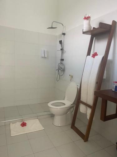 a bathroom with a toilet and a shower stall at Minah Bungalows in Nungwi