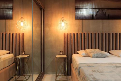 a bedroom with two twin beds and two lamps at Villa Besca with heated infinity pool in Baška