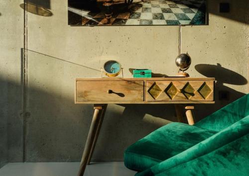 a wooden table with a green couch and a mirror at Villa Besca with heated infinity pool in Baška