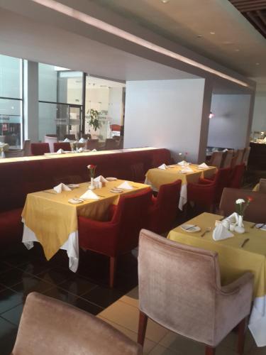 a restaurant with two tables and chairs with yellow table cloth at Boma Inn Eldoret in Eldoret