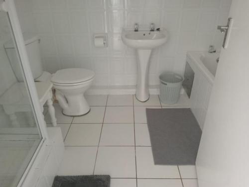 a white bathroom with a toilet and a sink at Laguna La Crete 163 in Margate