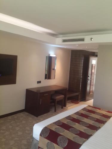 a bedroom with a bed and a desk and a television at Boma Inn Eldoret in Eldoret
