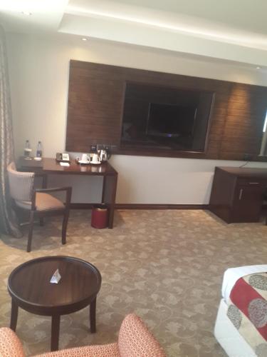 a living room with a desk and a tv in a hotel room at Boma Inn Eldoret in Eldoret