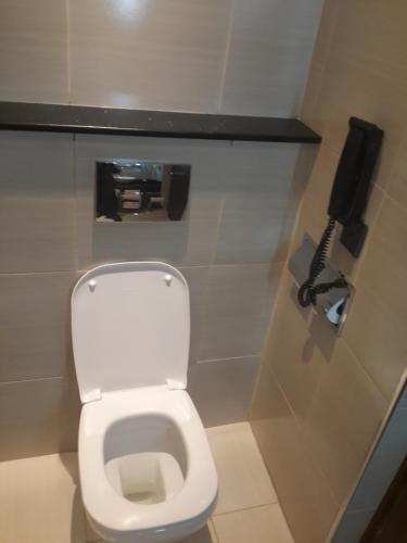 a bathroom with a toilet and a phone on the wall at Boma Inn Eldoret in Eldoret