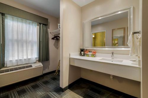 a bathroom with a sink and a large mirror at Best Western Plus Cold Spring in Plymouth