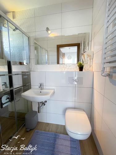 a bathroom with a sink and a toilet and a mirror at Stacja Bałtyk in Karwia