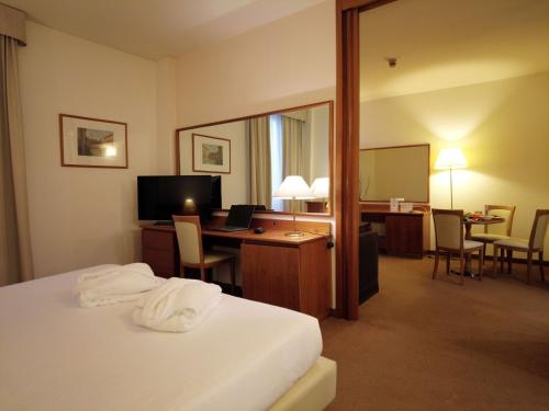 um quarto de hotel com uma cama e uma secretária com um computador em Best Western Park Hotel em Piacenza