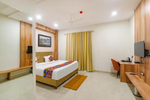 a bedroom with a bed and a desk and a tv at FabHotel The Nawab's in Nalmatha