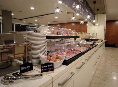 a buffet line in a restaurant with eggs and meat at Best Western Park Hotel in Piacenza