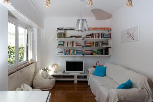 a living room with a white couch and a tv at Flat With a Garden in Belem in Lisbon