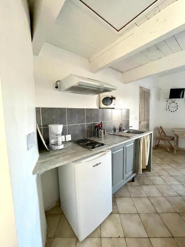 a kitchen with white cabinets and a counter top at Le petit chalus in Forcalquier