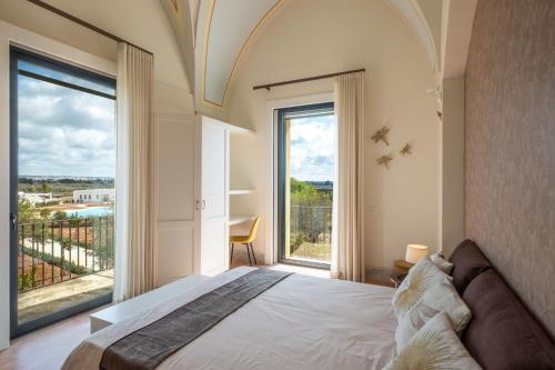 a bedroom with a large bed and a large window at Tenuta Rocci Cerasoli in Parabita