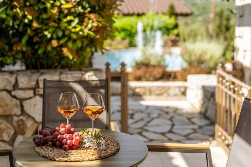 une table avec deux verres de vin et de raisin dans l'établissement Sivota Diamond Spa Resort, à Sivota