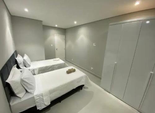 ein weißes Schlafzimmer mit 2 Betten und einer Dusche in der Unterkunft Apartamento moderno em Copacabana in Rio de Janeiro
