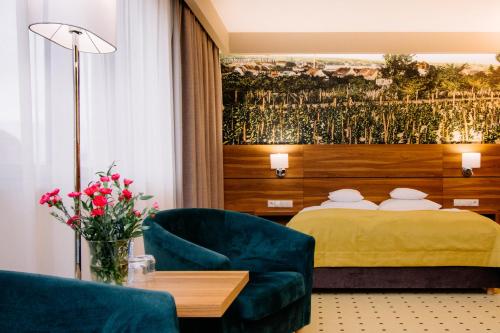 a hotel room with a bed and a couch and a table at Ruben Hotel Zielona Góra in Zielona Góra