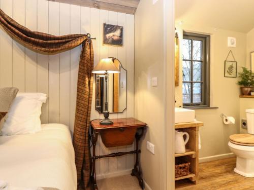 a bedroom with a bed and a sink and a mirror at The Badger's Shack in Kendal
