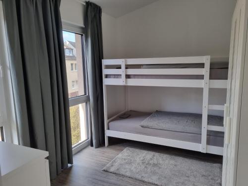 1 dormitorio con 2 literas y ventana en Ferienwohnung Euchen en Würselen