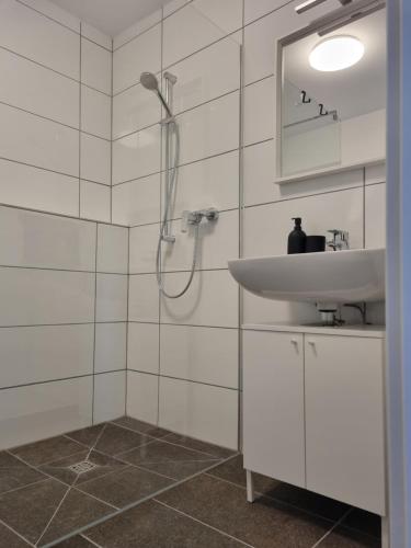 a white bathroom with a sink and a shower at Ferienwohnung Euchen in Würselen