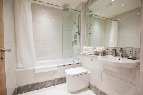 a bathroom with a toilet and a sink and a shower at Sanctum Belsize Road in London
