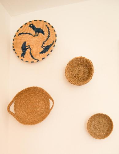 three baskets on a white table with a plate at Sotza’s Little House in Padru