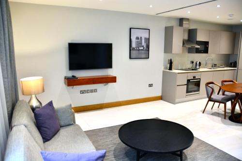 a living room with a couch and a table at Sanctum Belsize Road in London