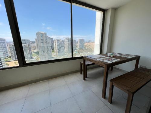 a table and bench in a room with a large window at Apartment Isa Concón in Concón
