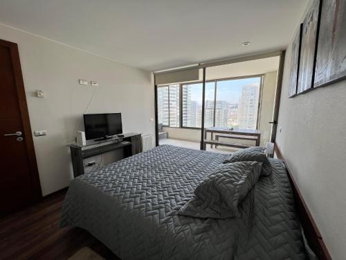 a bedroom with a bed and a large window at Apartment Isa Concón in Concón